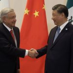 AMLO and Xi shake hands in front of a Chinese flag