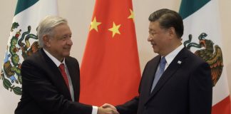 AMLO and Xi shake hands in front of a Chinese flag