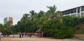 A beach with police and a body bag, cordoned off