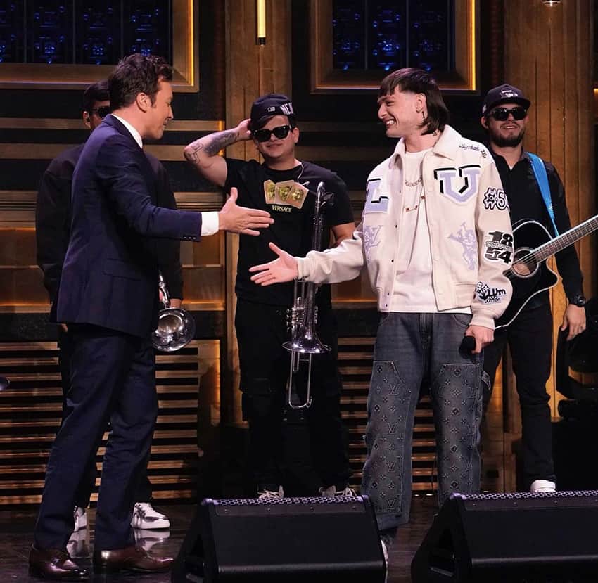 Peso Pluma shakes hands with Jimmy Fallon on stage on the Tonight Show
