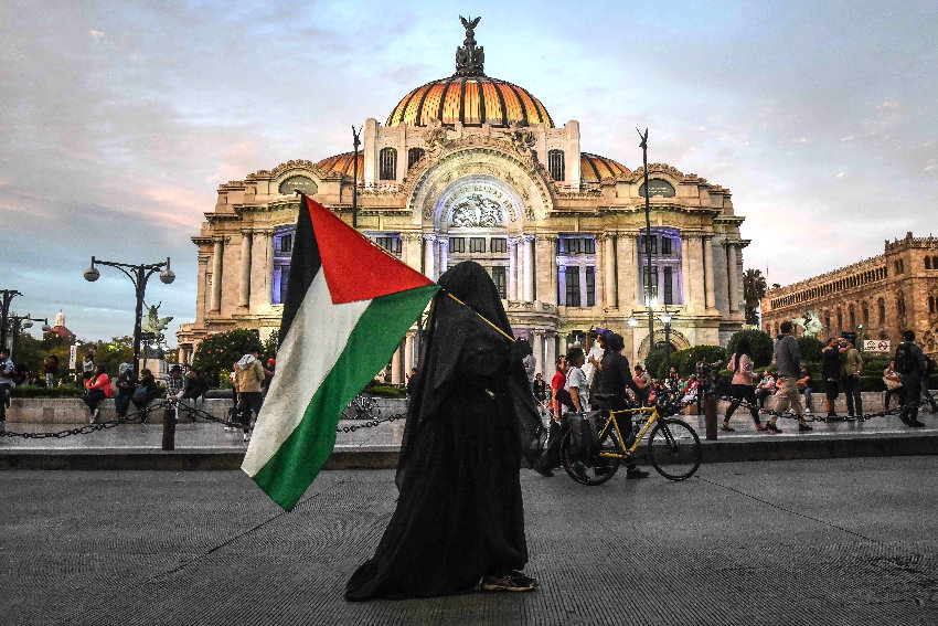 A person with a Palestinian flag in front of the Bellas Artes Palace in Mexico City