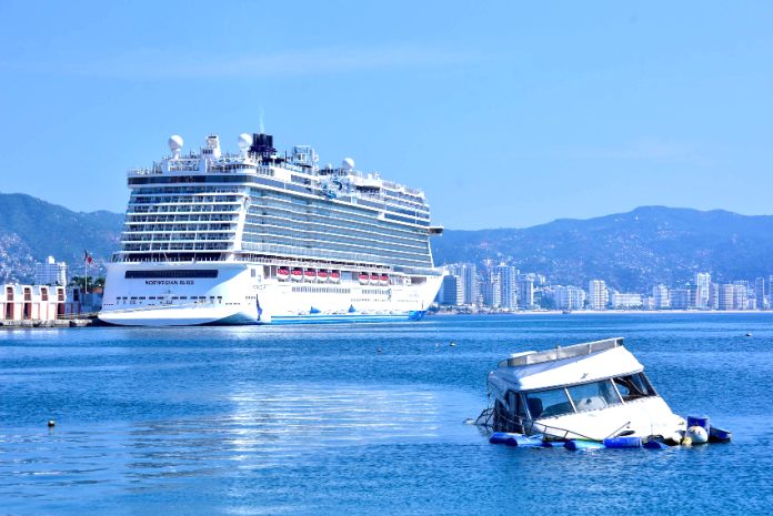 A cruise ship in Acapulco Bay with a sunken boat in the foreground