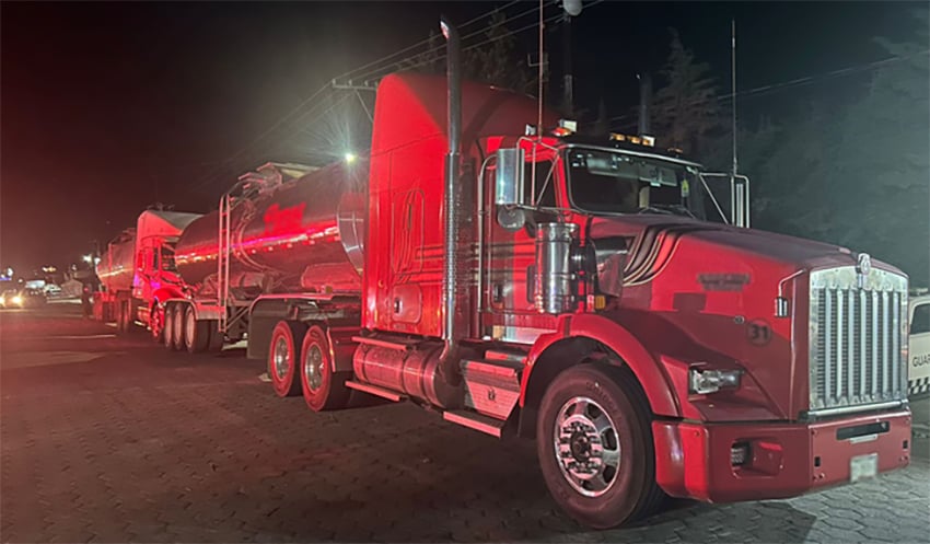 Two semi-trailers lit by red light at night