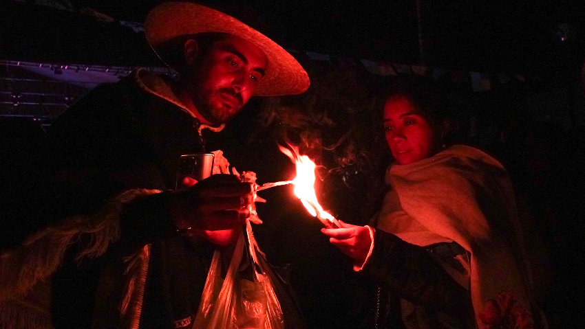 Two people light a flame in Michoacán ceremony