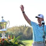 Jake Knapp waves at the crowd and accepts his golf trophy