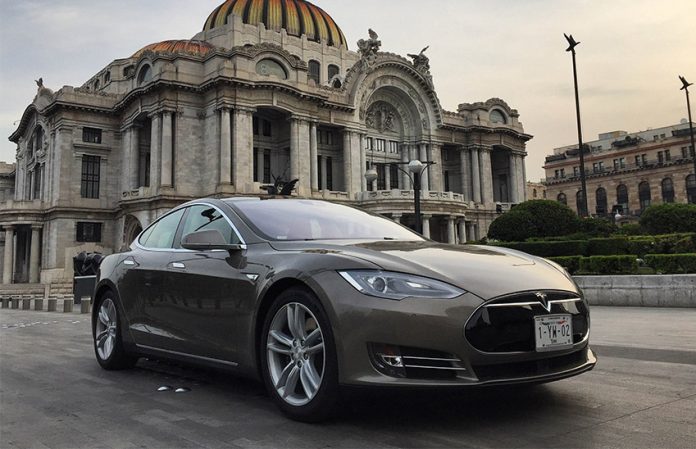 A Tesla vehicle drives past the Palacio de Bellas Artes in Mexico City