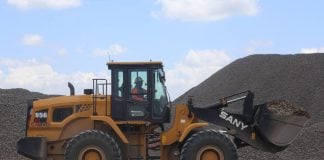 A front end loader moves ballast as it prepares a section of track for the Maya Train in Yucatán