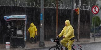 A person bicycles in the rain in Mexico City