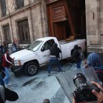 Protesters ramming a car through an entrance to Mexico City's National Palace on March 6, 2024