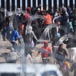 Migrants negotiate a razor wire barrier as they cross from Ciudad Juárez in Mexico to El Paso, Texas, in the U.S.