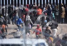 Migrants negotiate a razor wire barrier as they cross from Ciudad Juárez in Mexico to El Paso, Texas, in the U.S.