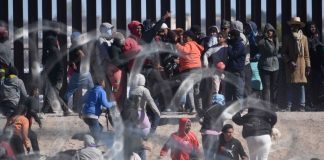 Migrants negotiate a razor wire barrier as they cross from Ciudad Juárez in Mexico to El Paso, Texas, in the U.S.