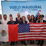 Airline and airport employees pose with a Mexican and a U.S. flag