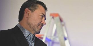 Photo of Mexican journalist Jaime Barrera in a suit posing with his arms crossed