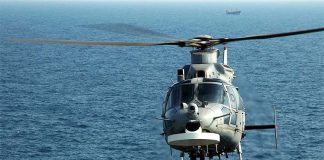 An Airbus AS565 Panther helicopter in flight over the ocean