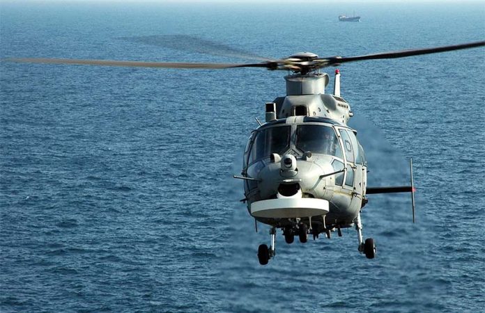 An Airbus AS565 Panther helicopter in flight over the ocean