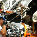 A man works at a car manufacturing plant, representing a decrease in unemployment in Mexico