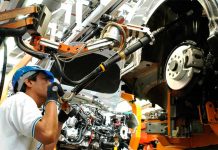 A man works at a car manufacturing plant, representing a decrease in unemployment in Mexico