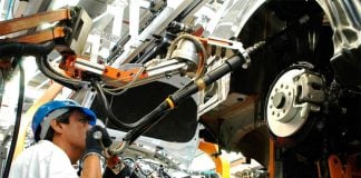 A man works at a car manufacturing plant, representing a decrease in unemployment in Mexico