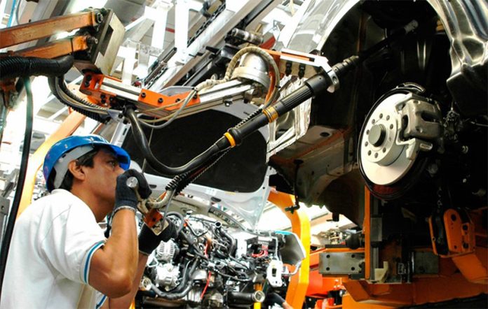 A man works at a car manufacturing plant, representing a decrease in unemployment in Mexico