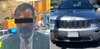 A police photo of a man in a suit with his eyes covered for anonymity