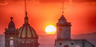 The sun sets behind San Miguel's Church of the Immaculate Conception