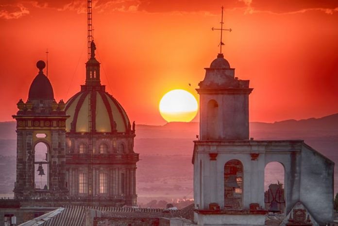 The sun sets behind San Miguel's Church of the Immaculate Conception