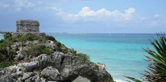 A Maya ruin on a cliff over the turquoise-blue sea
