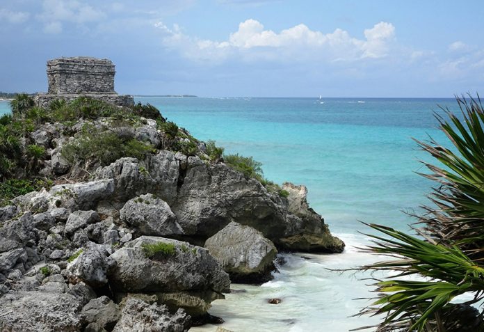 A Maya ruin on a cliff over the turquoise-blue sea