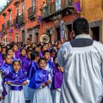 Children's choir sings in a Good Friday procession. Holy Week events attract thousands of visitors to this colonial town in Mexico.