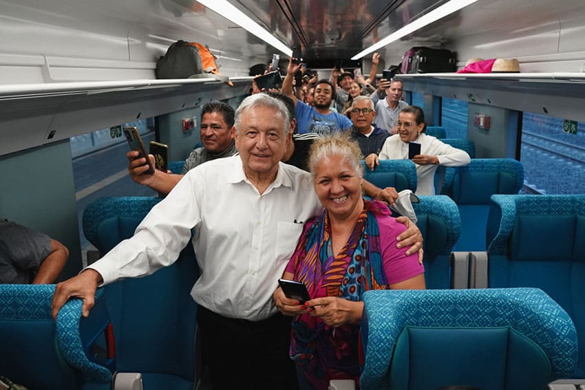 Mexico's President Lopez Obrador posing with a citizen inside a car of the Maya Train