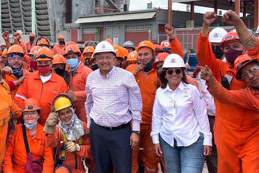 President of Mexico Andres Manuel Lopez Obrador posing with Pemex workers in orange suits