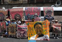 Protesters in Mexico City display banners demanding justice for murdered environmental activist Samir Flores and other causes related to environmental defense.