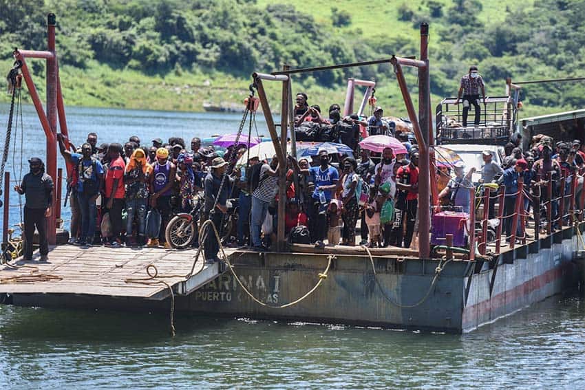 Migrantes de pie en un ferry que cruza el embalse de Angostura en Chiapas.