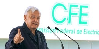 López Obrador with CFE sign behind him