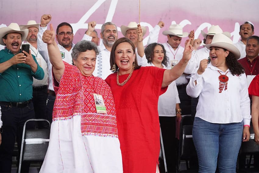 Mexican senator Beatriz Paredes raising hand with Xochitl Galvez standing in front of supporters