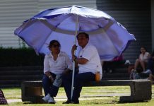 A couple brings their own shade to a Mexico City park in late March.