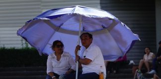 A couple brings their own shade to a Mexico City park in late March.