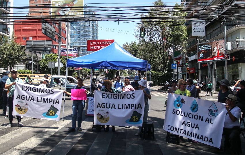 Mexico City protesters holding signs demanding clean water