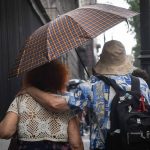 A couple shares an umbrella in a rainstorm