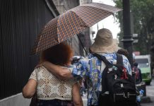 A couple shares an umbrella in a rainstorm