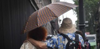 A couple shares an umbrella in a rainstorm