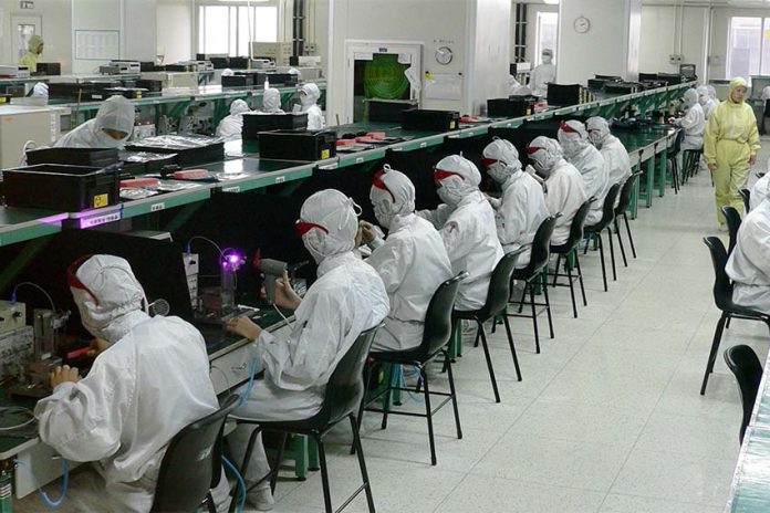 Rows of seated workers at a Foxconn electronics factory in Shenzhen, China
