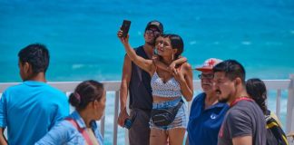 A tourist takes a selfie on a beach in Quintana Roo