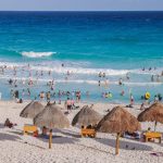 People enjoy the sand and sea on the beach in Tulum