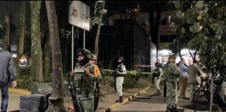 Military stand next to a sealed-off well