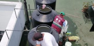 Mexico City water authority workers clean out cisterns atop an apartment building.