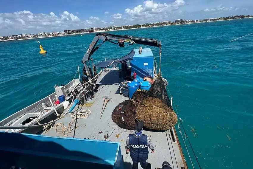 Navy boat off the coast of Quintana Roo, Mexico collecting sargassum from the ocean