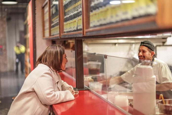 Xóchitl Gálvez talks with a Mexican at eatery counter in New York City