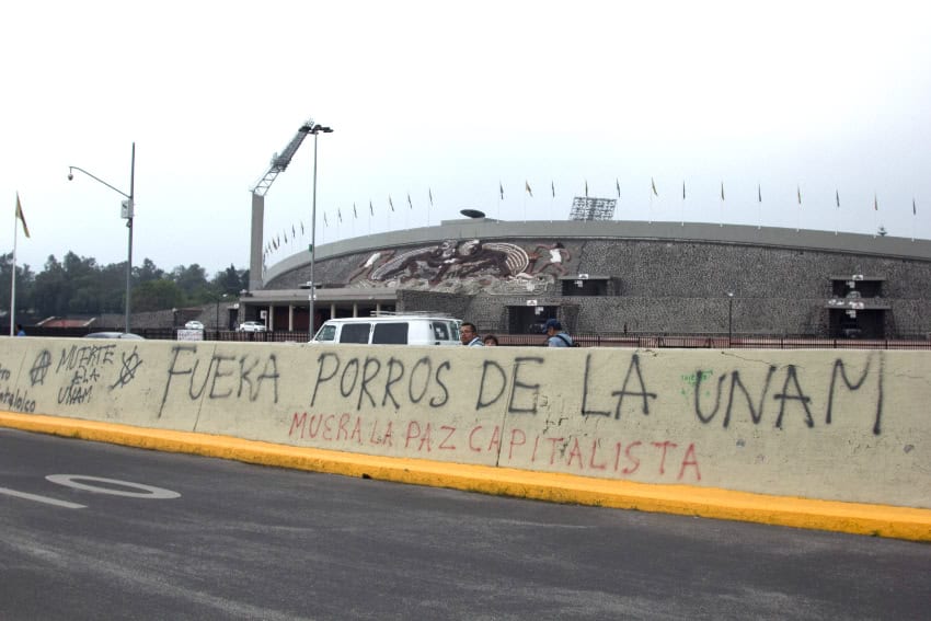Graffiti on a median that reads "Get porros out of UNAM"
